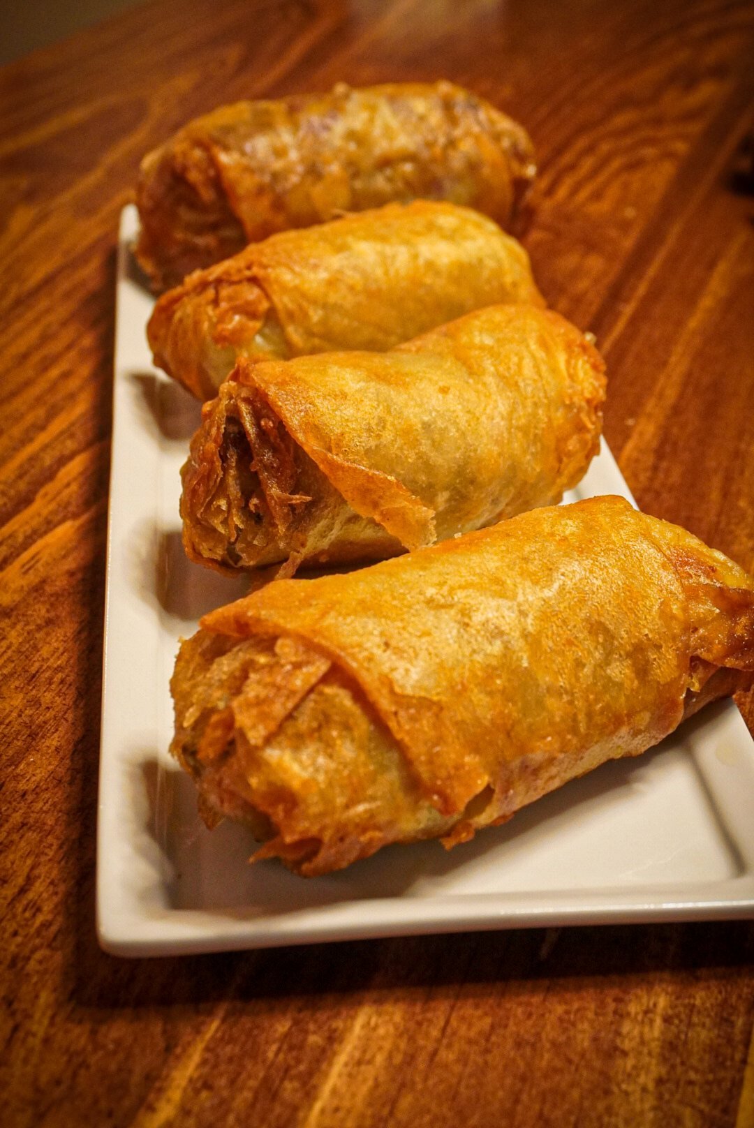 Rollitos fritos sobre plato blanco